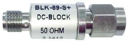 A cylindrical DC blocker marked 'BLK-89-S+', 'DC-BLOCK', '50 OHM', is used to block direct current in signal cables.