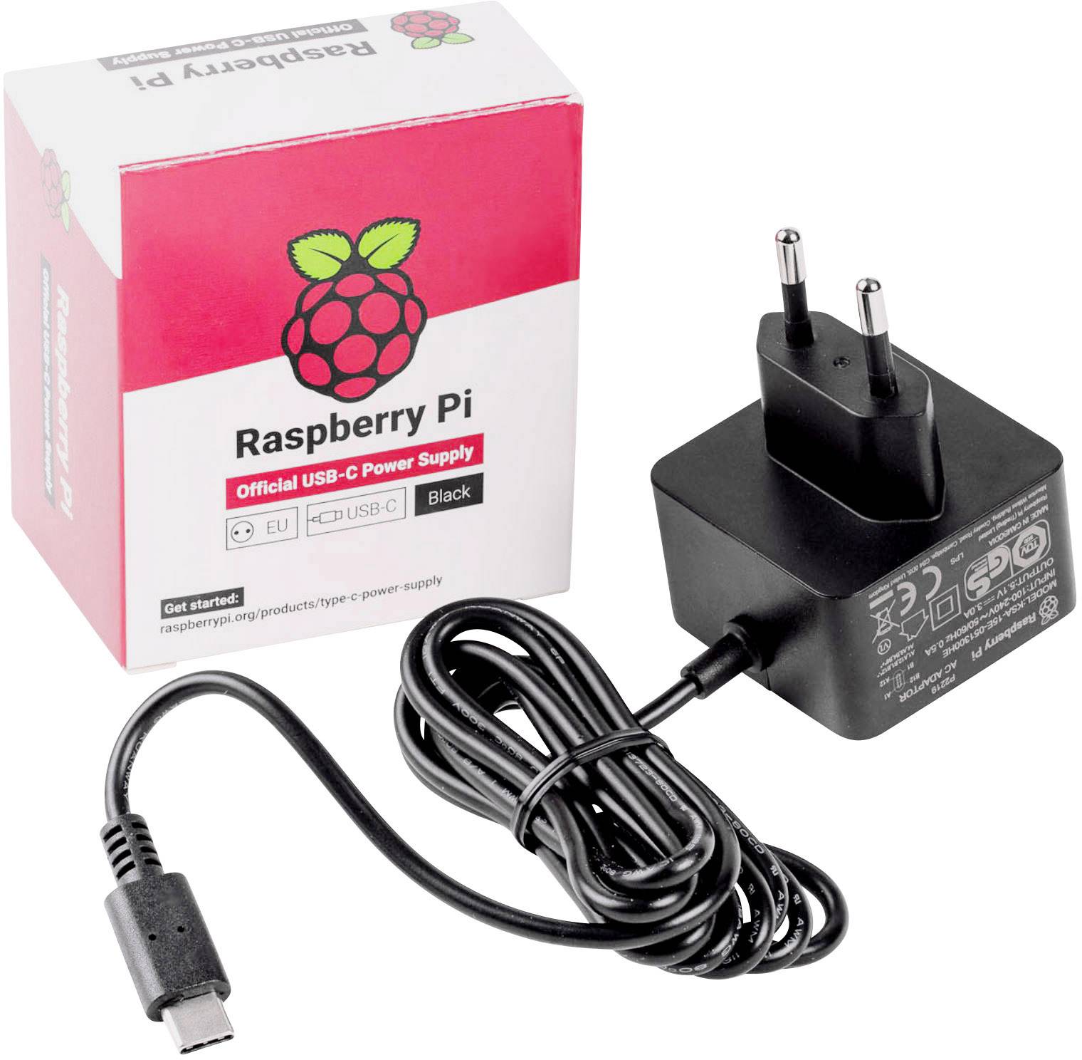 A Raspberry Pi USB-C power supply next to a red and white packaging with a raspberry logo and the inscription 'Raspberry Pi'.