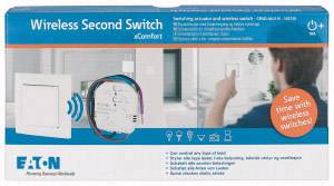 A packaging displays a wireless switch from Eaton and electronic components. A man is operating the switch on the wall.