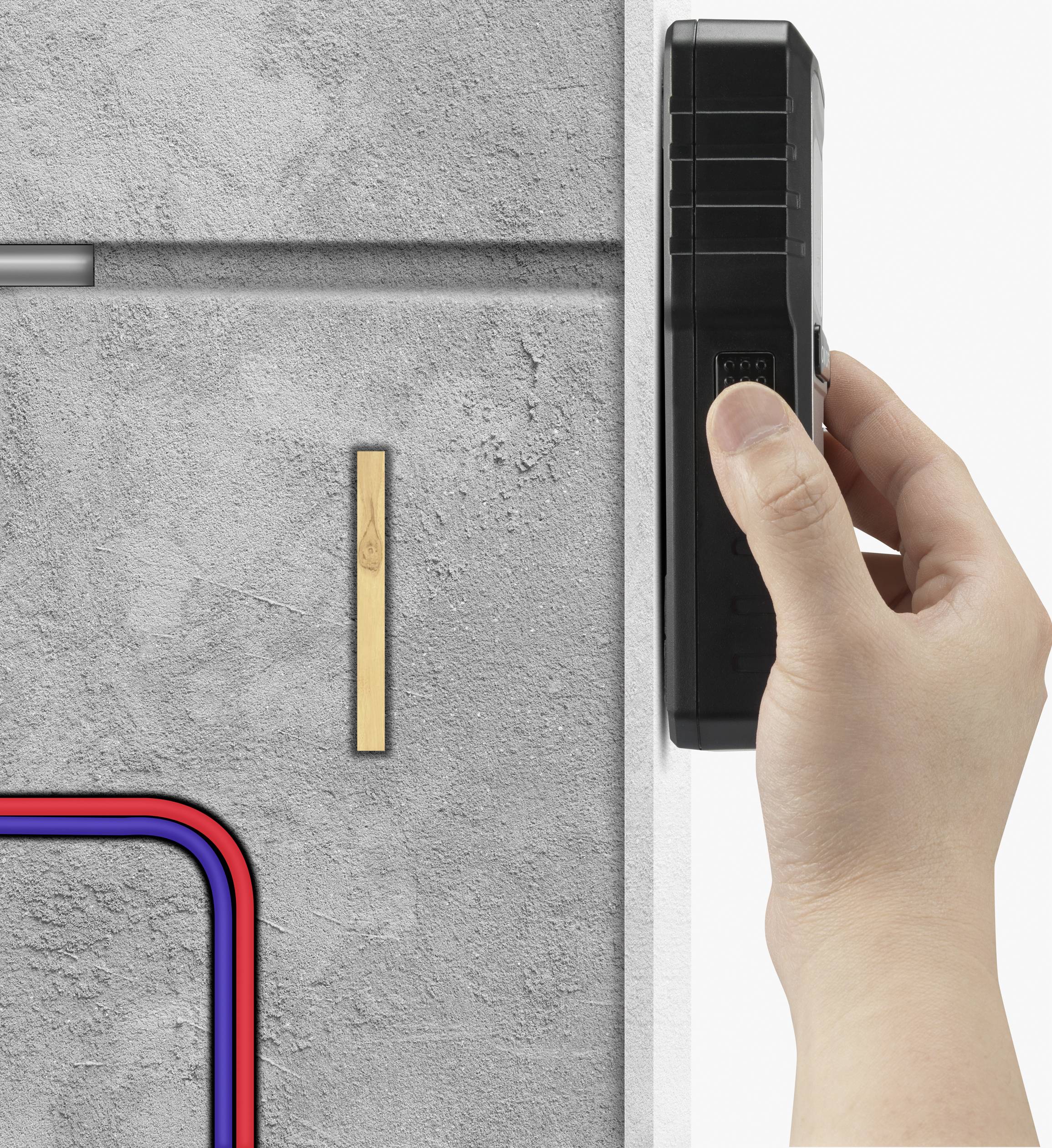 A hand is holding a device against a concrete wall, with coloured cables and a wooden batten situated nearby.