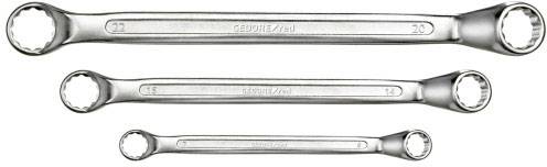Three gleaming ring keys of different sizes lie parallel to each other on a white background.