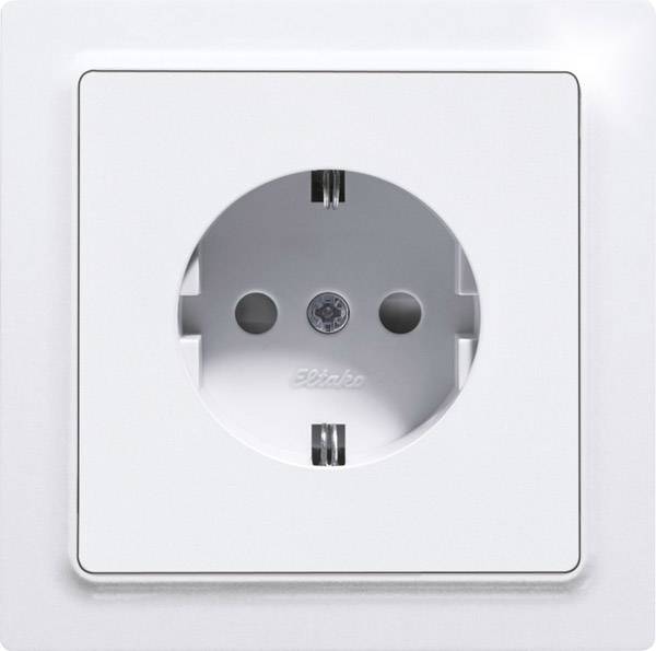 White European electrical socket without a plug inserted, mounted on a white wall. Focus is on the round opening.
