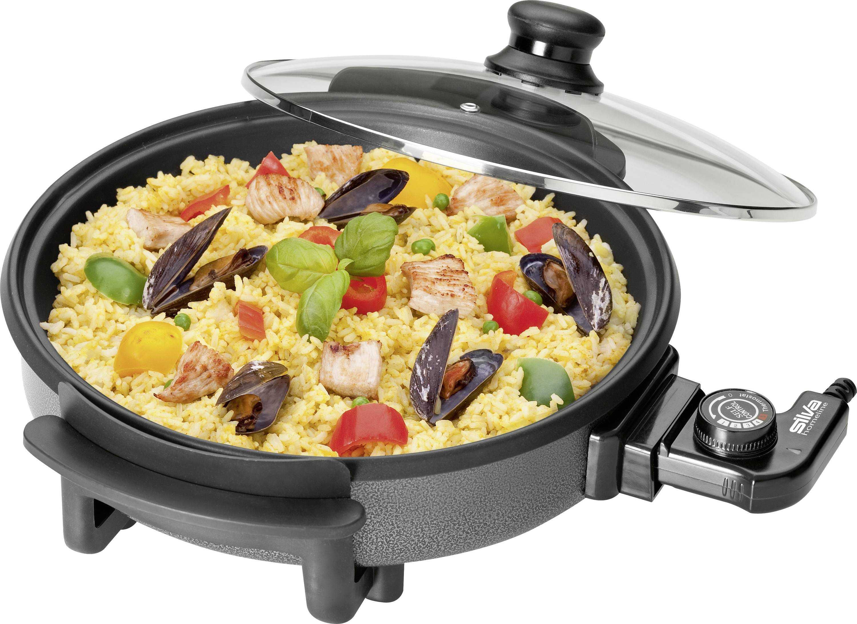 Electric frying pan with paella: Risotto with green and red pepper pieces, mussels, chicken pieces and herb garnish with lid open.