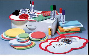 Various coloured index cards, markers, drawing pins and glue stick in front of a board, suitable for presentation preparation.