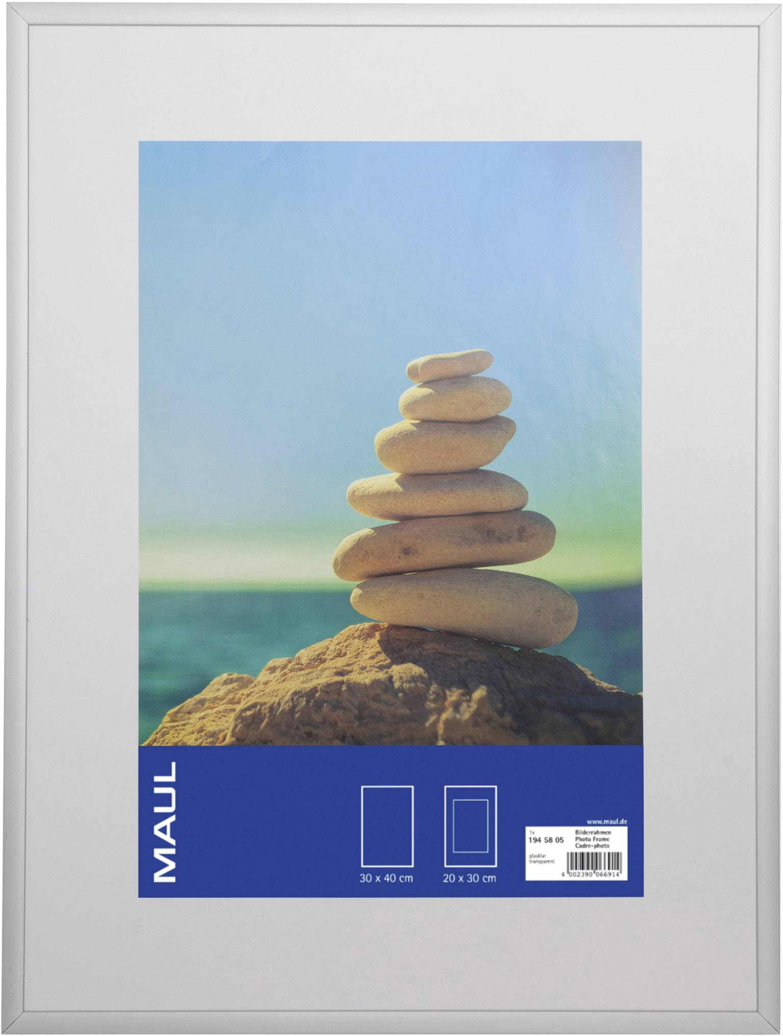 A stack of smooth stones balances on top of each other on a rock, with a blue sky in the background.