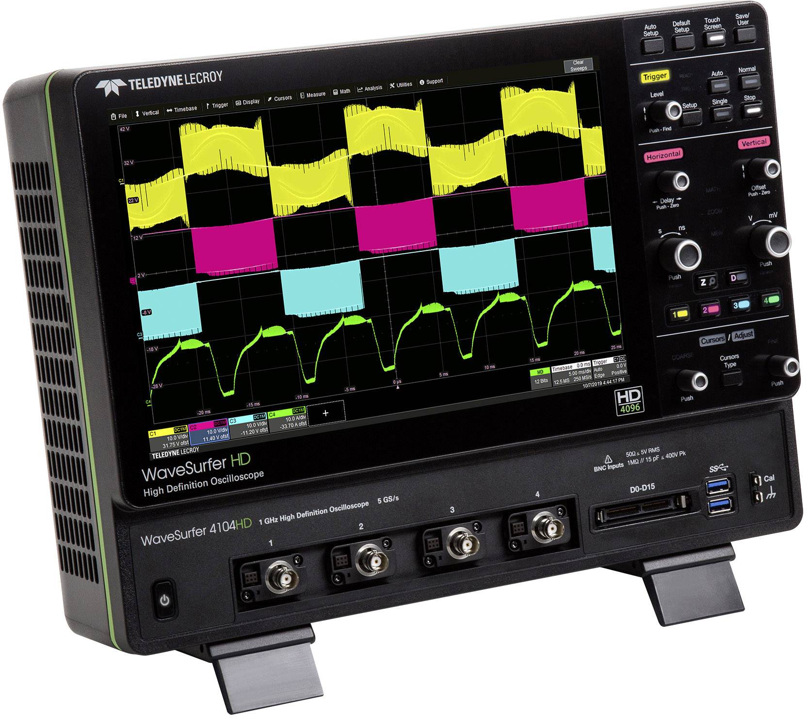 Oscilloscope with a colour display showing four overlapping waveform signal patterns. Controls and connectors are located on the front panel.