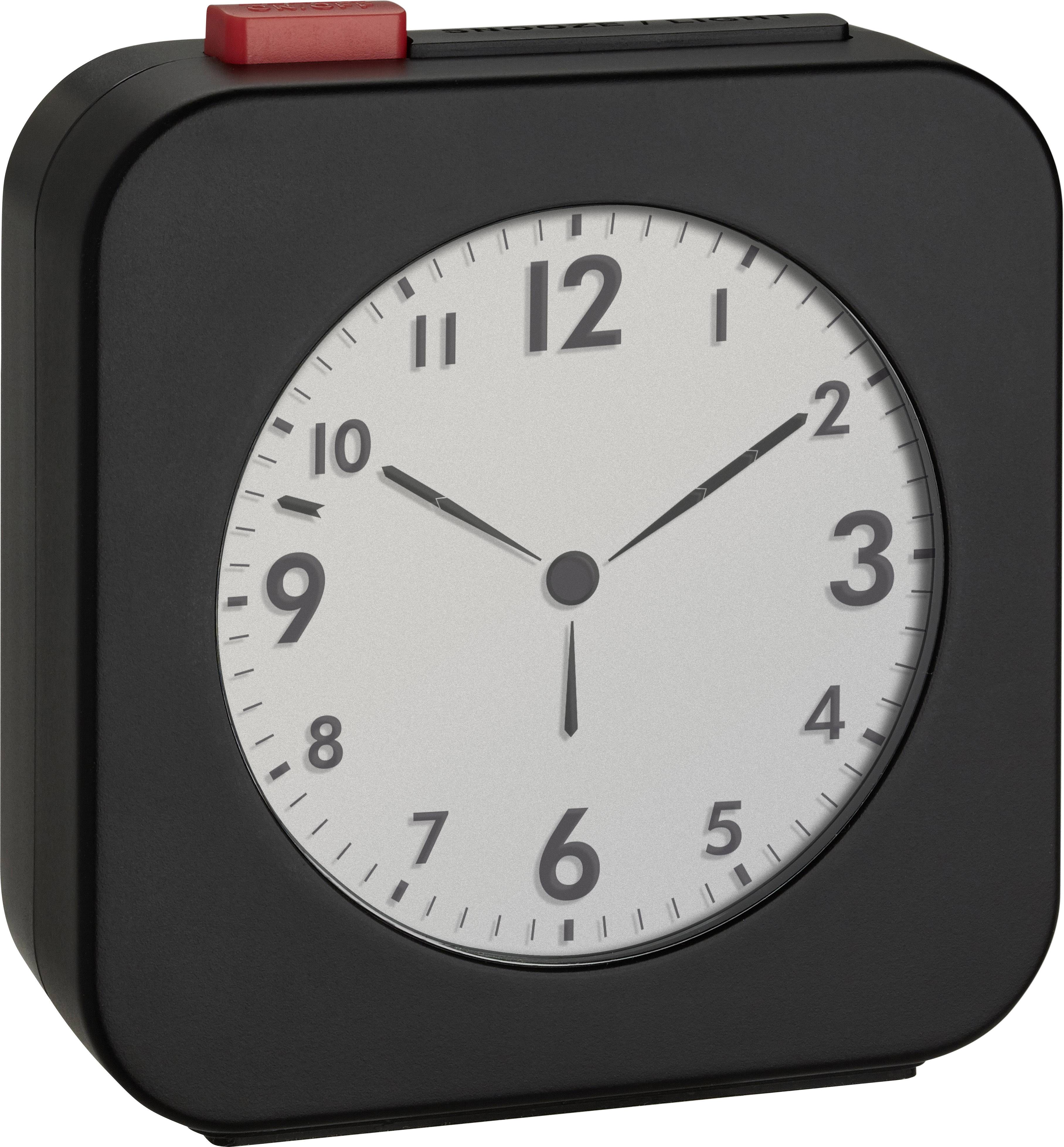 A rectangular black alarm clock with a white dial and black numbers displays the time as 10:10.