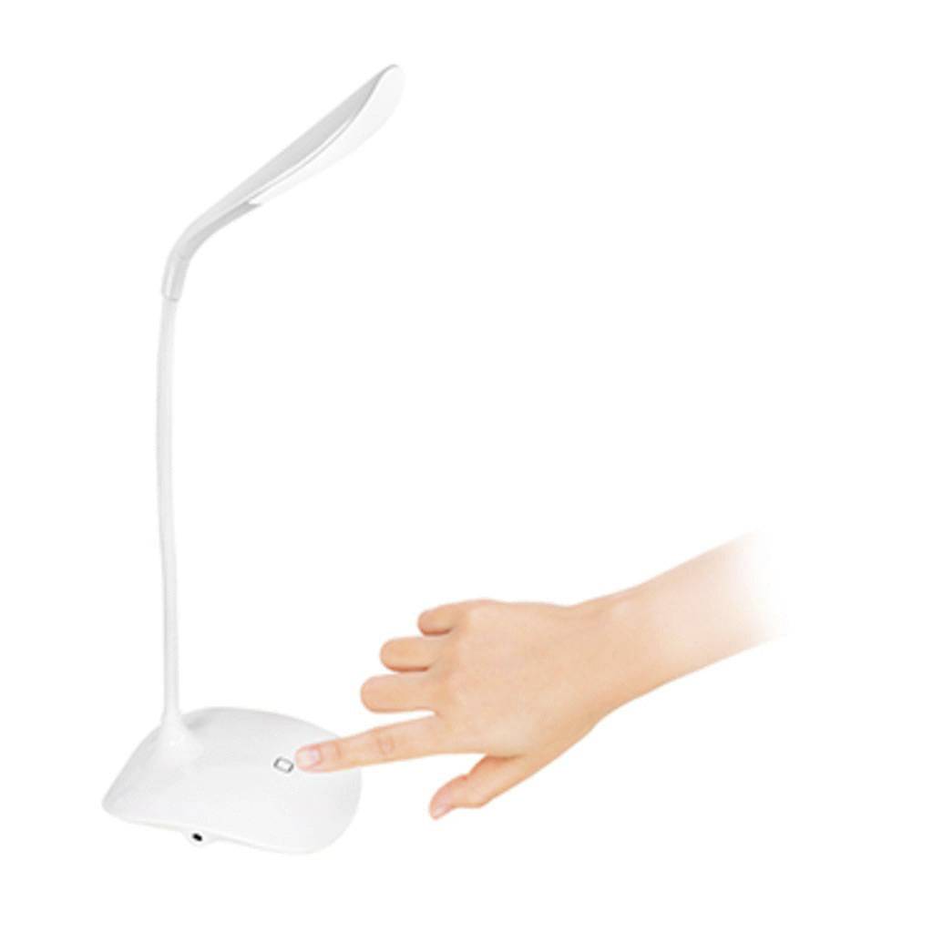 A hand touches the power button of a modern, white desk lamp with a flexible neck.
