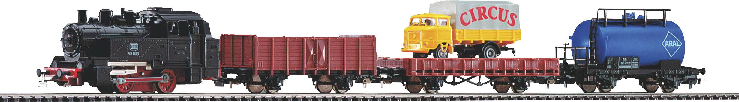 Model railway train on a track. The train consists of a black locomotive and several freight wagons, including a tanker and an open wagon with lorry models.