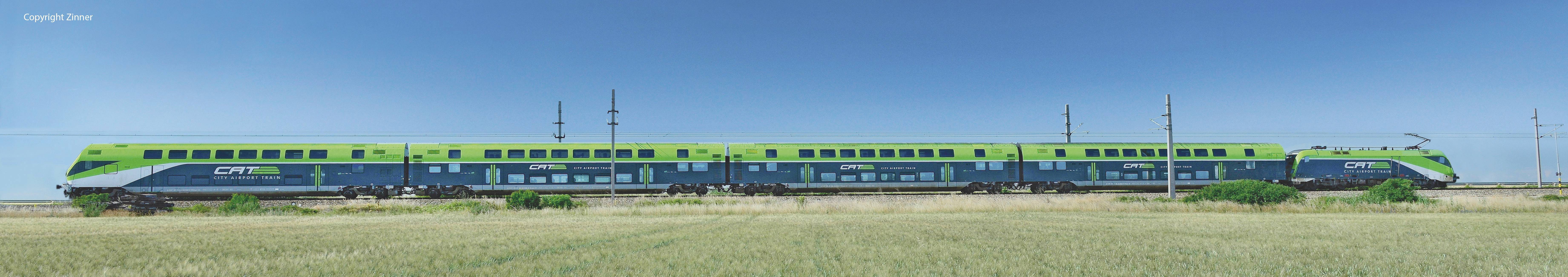A green and blue high-speed train is travelling through a rural landscape under a clear sky.