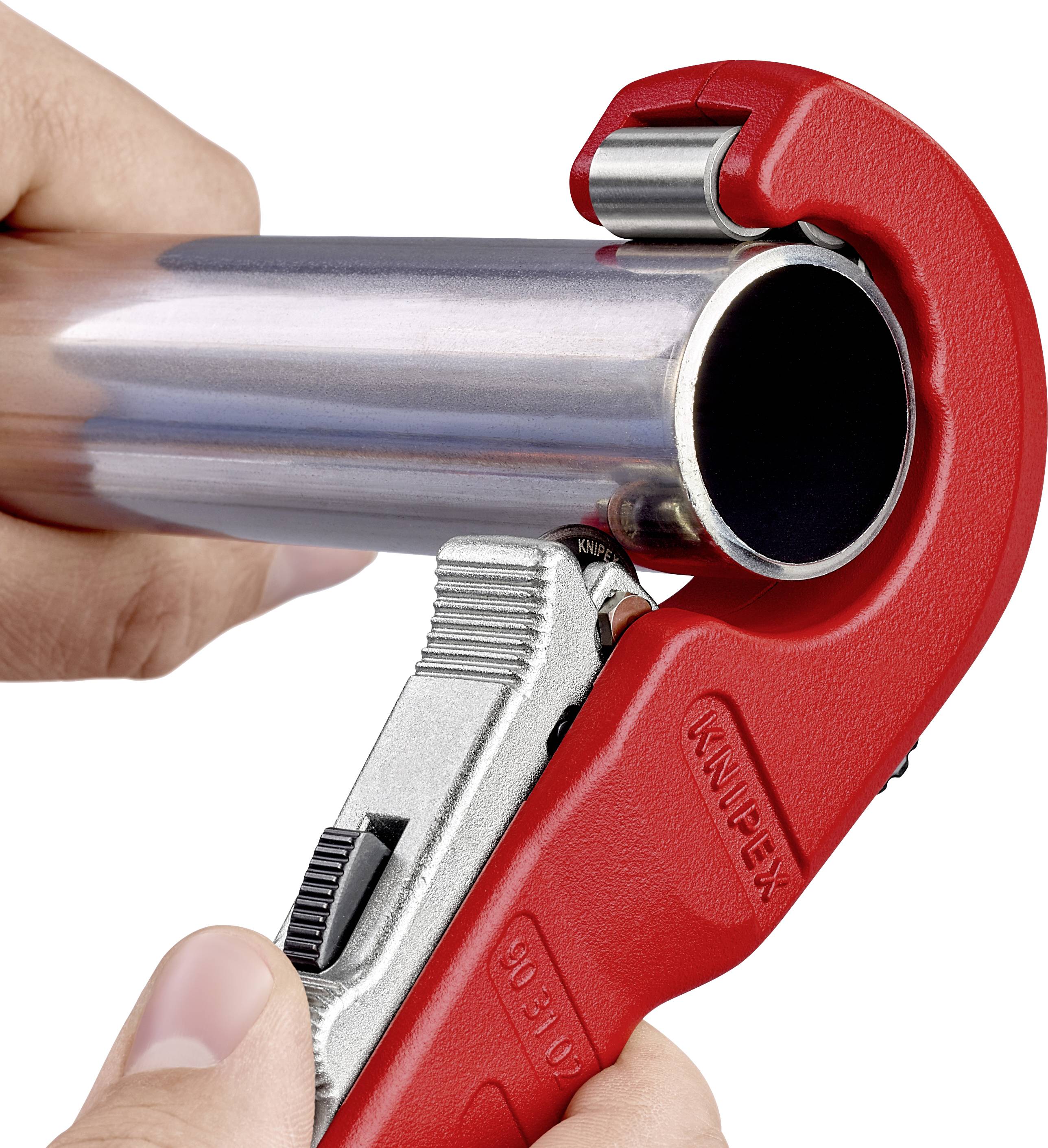 A hand is using a red pipe cutter to cut a metal pipe. The cutter has a silver blade and is attached.