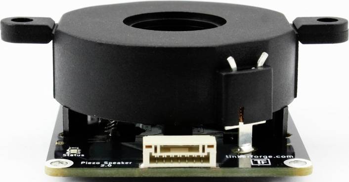 An electronic component with a round, black cover and connection on a circuit board, possibly a piezo speaker.