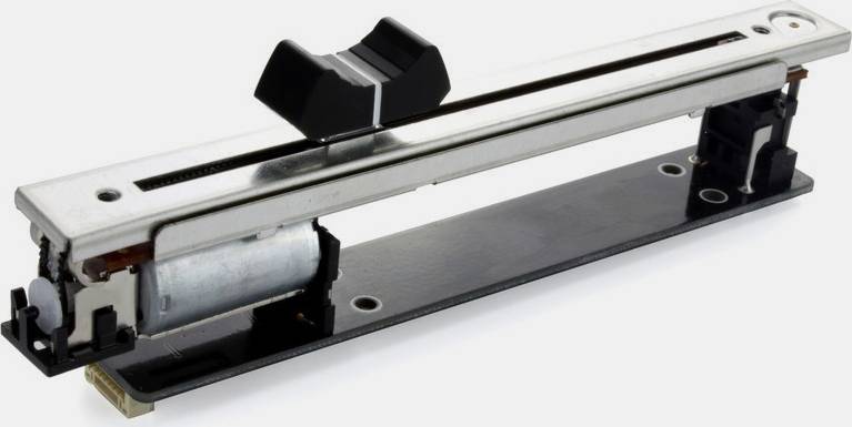 A horizontal fader, as used in audio equipment, with a black slider positioned in the centre of a metal rail.
