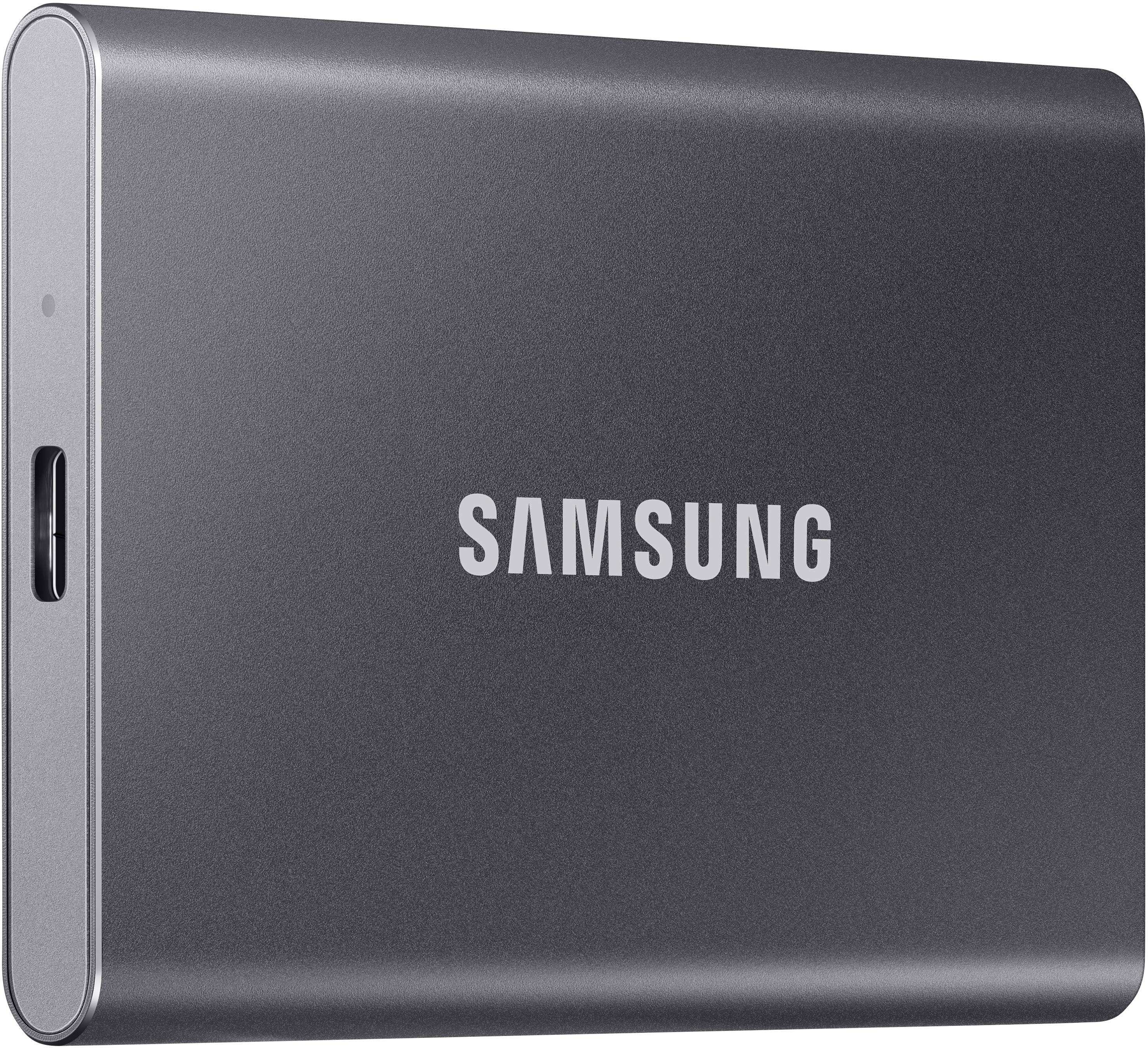 External Samsung SSD hard drive, grey casing, with USB-C port on the side. Brand name 'SAMSUNG' on the front.