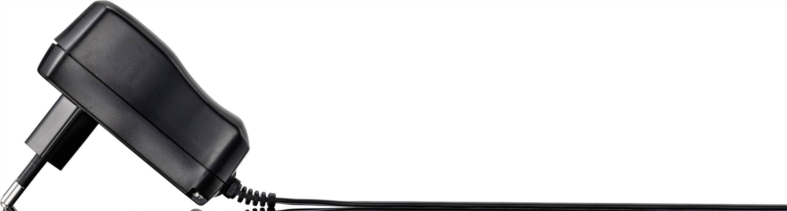 Power adaptor with cable, lying on a white background. Used for charging electronic devices.