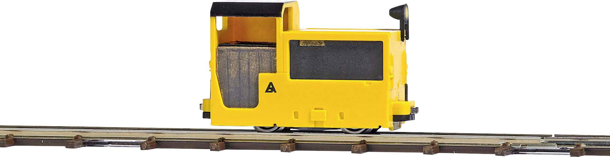 A small, yellow model vehicle on rails representing a locomotive. It has an open driver's area and black details.