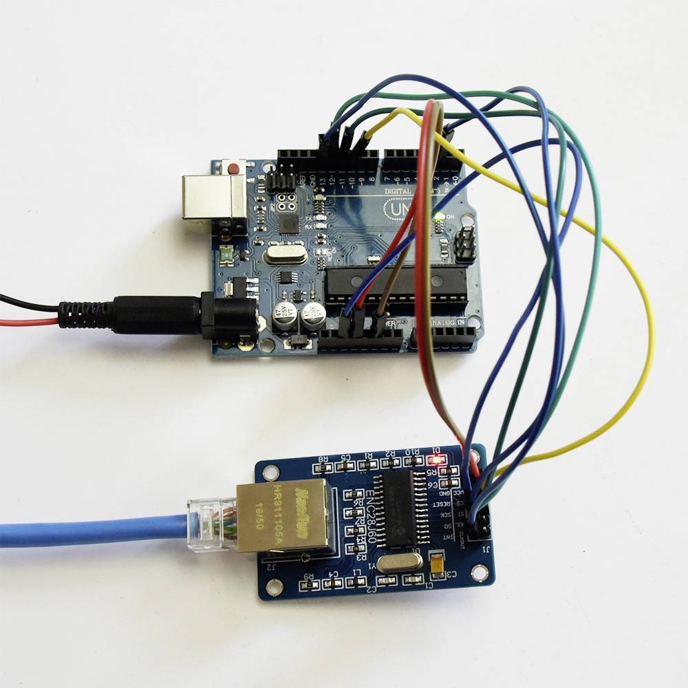Arduino board with multiple colourful cables connected to an Ethernet shield. The setup is used for electronic control and networking.