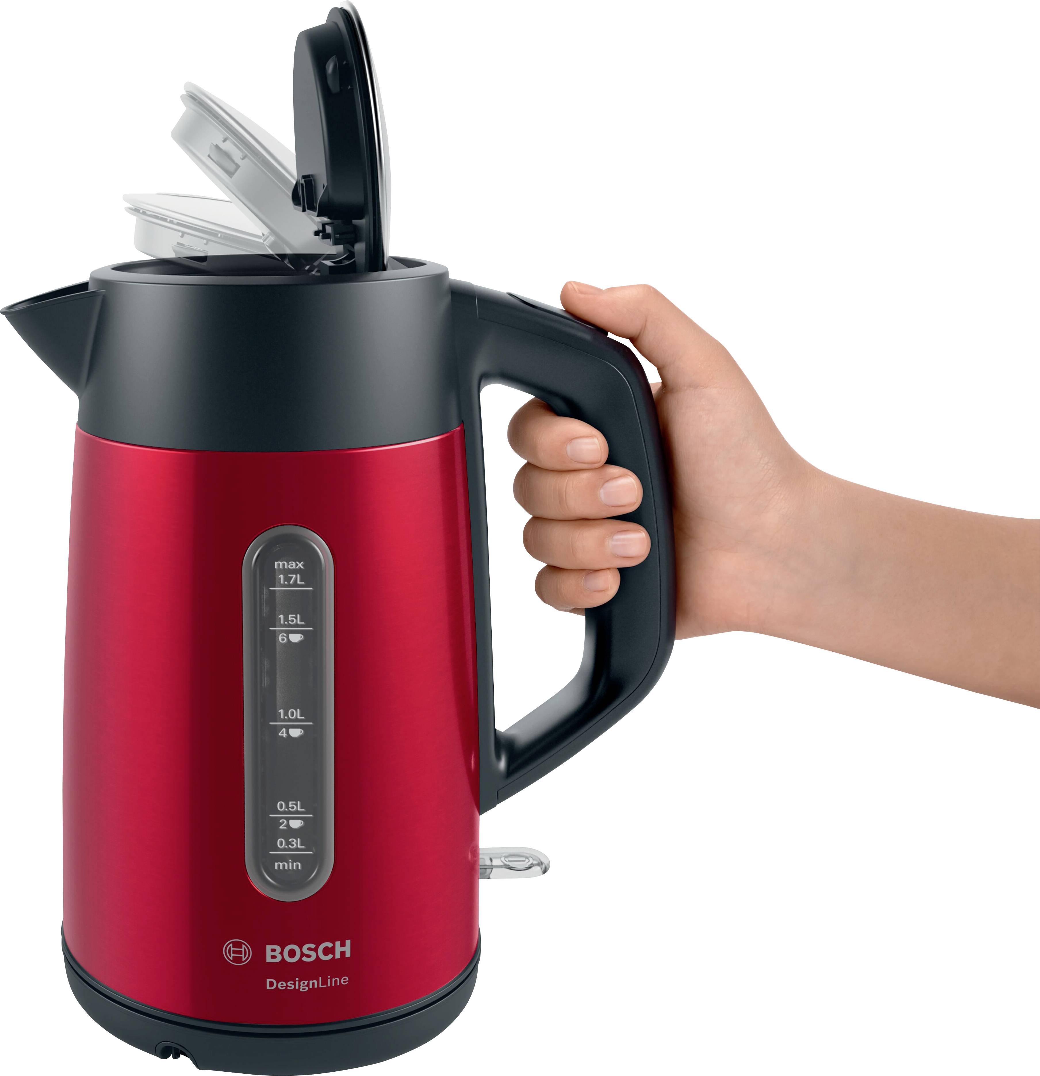 A hand is holding a red kettle with a black handle. The kettle has a transparent window with a water level indicator.