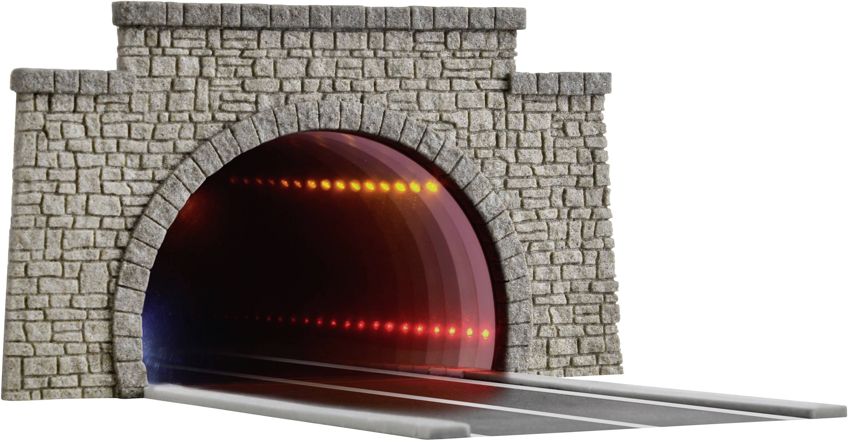 A model railway tunnel made of stone with an illuminated interior and tracks leading into darkness creates an impressive sense of depth.
