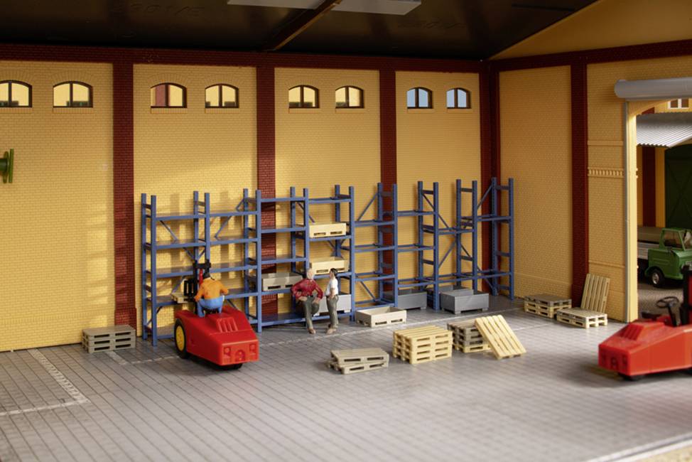 A miniature warehouse with figurines standing on pallets or working with a forklift. Shelving along the back wall.