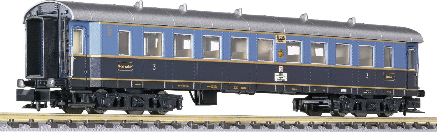 Model railway passenger carriage in blue and black paintwork on the track. The wagon has multiple rows of windows and detailed features.