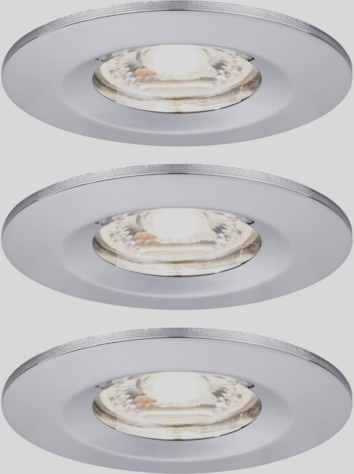Three recessed spotlights with matte metal housing, all switched on and illuminating, placed on a grey background surface.