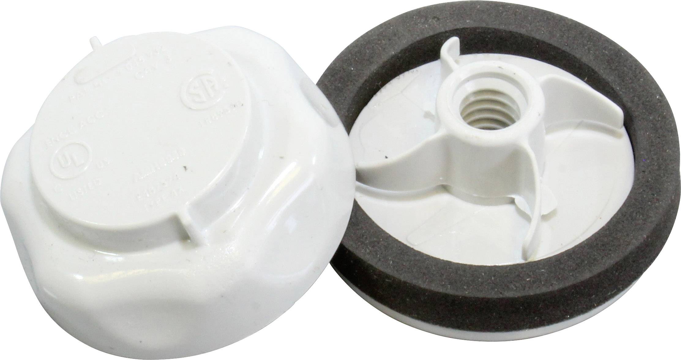 Two white, round plastic threaded caps, one with a black foam seal, are lying side by side.