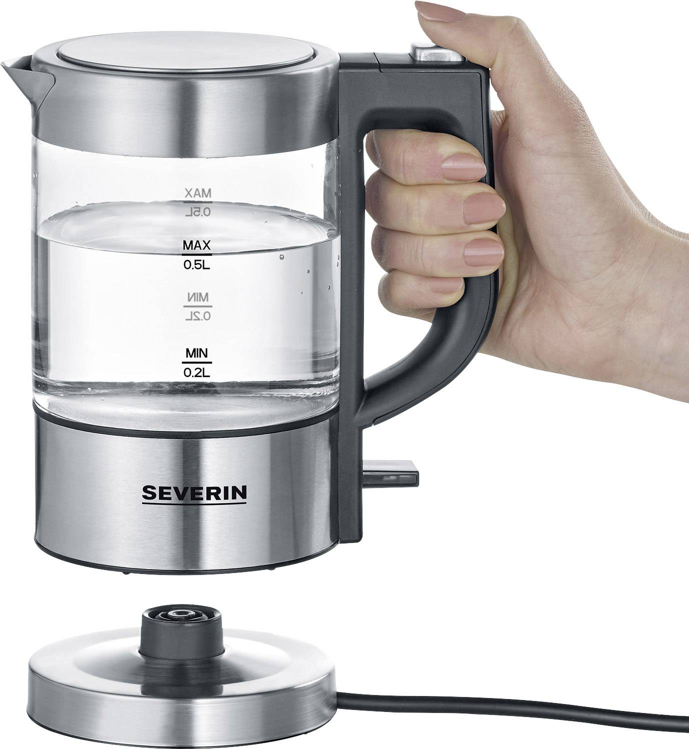 A hand is holding a small stainless steel kettle above its base. The water level is filled to half capacity.