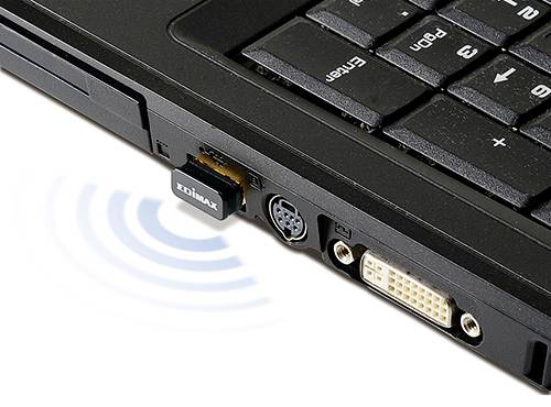 Close-up of a black laptop with a Wi-Fi adapter in the USB port. Wavy lines symbolise a wireless connection.
