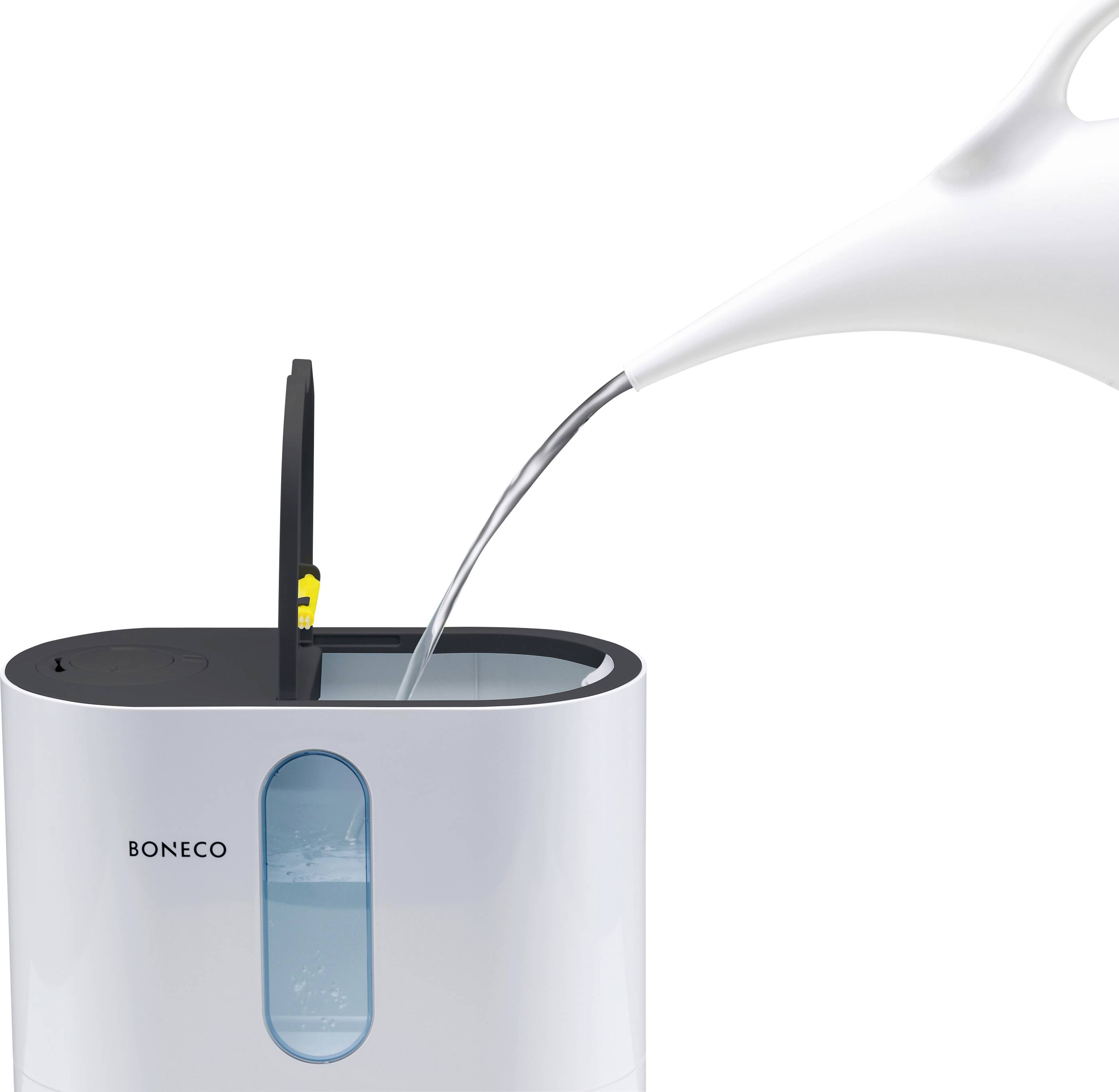Humidifier with an open water reservoir, into which water is being poured from a white jug.