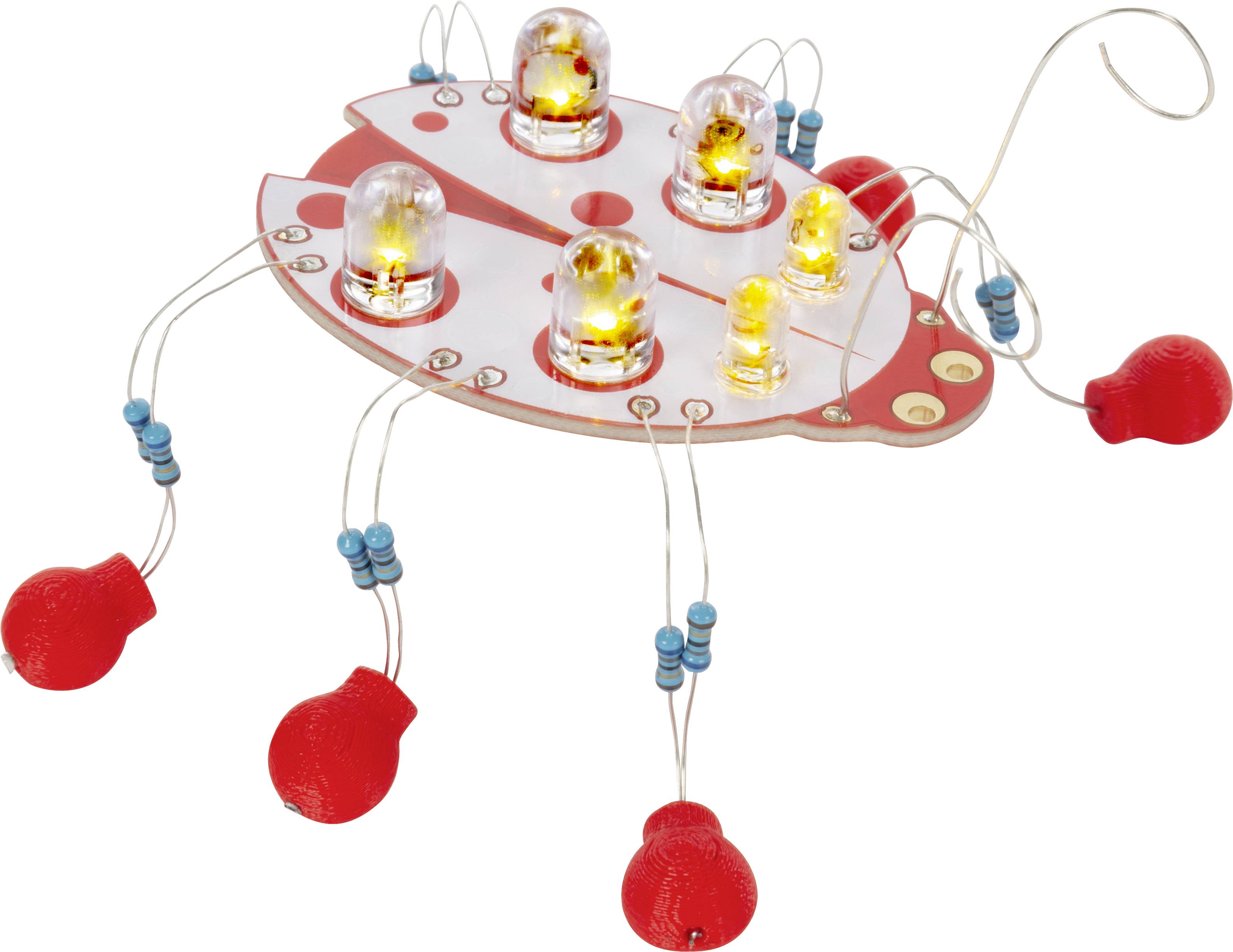 An electronic ladybird electronics kit with illuminating light bulbs and red wires. It demonstrates a simple circuit for learning electronics.