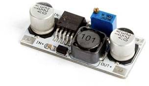 An electronic circuit with two cylindrical capacitors, a blue trimmer, and a black inductor.