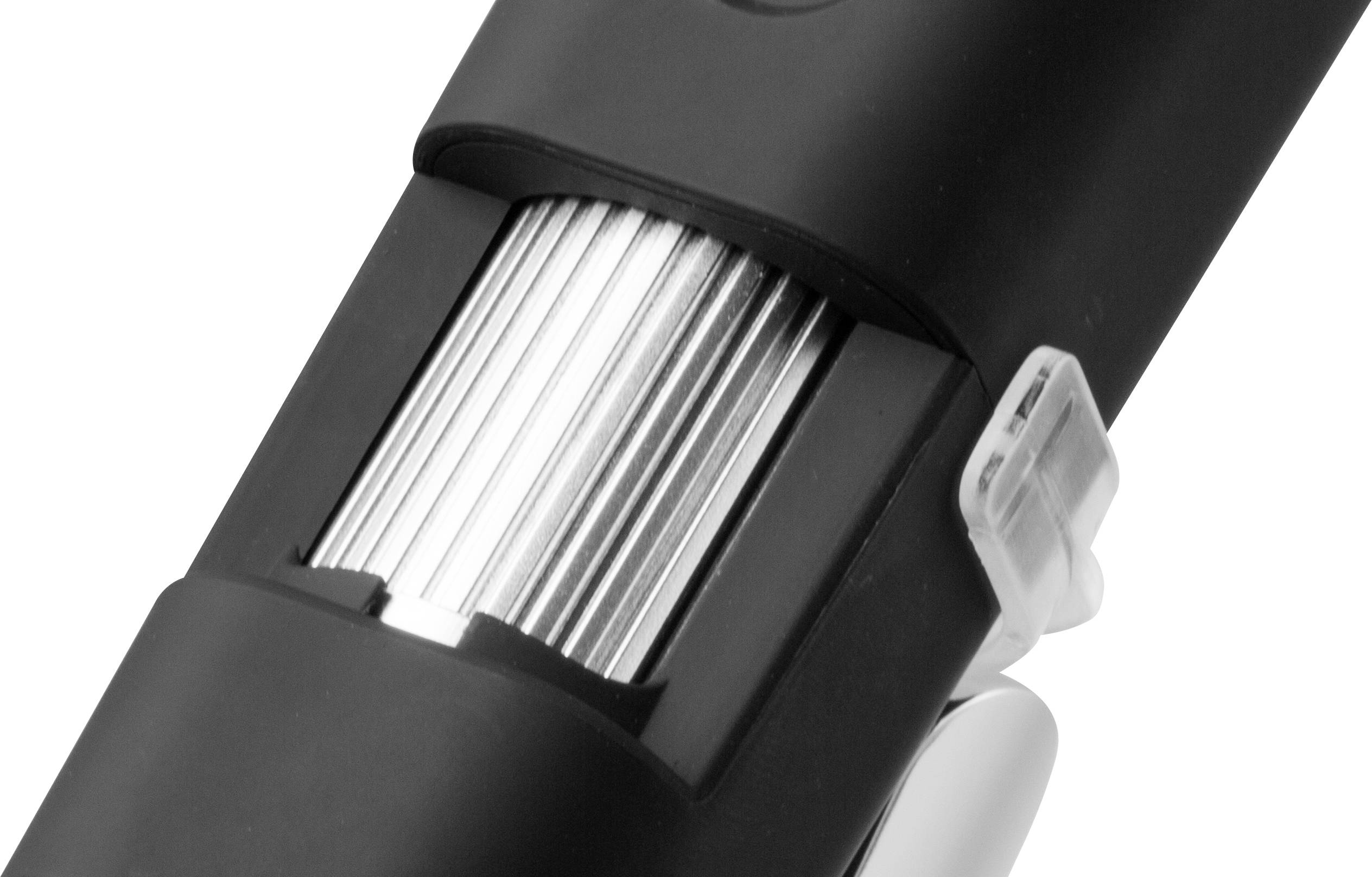 Electric razor in black, with silver blades and white switch, close-up, focus on functional details.