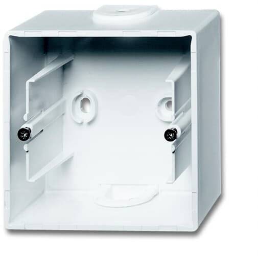 White surface-mounted electrical installation box, with two screw holes and cable routing, suitable for wall mounting.