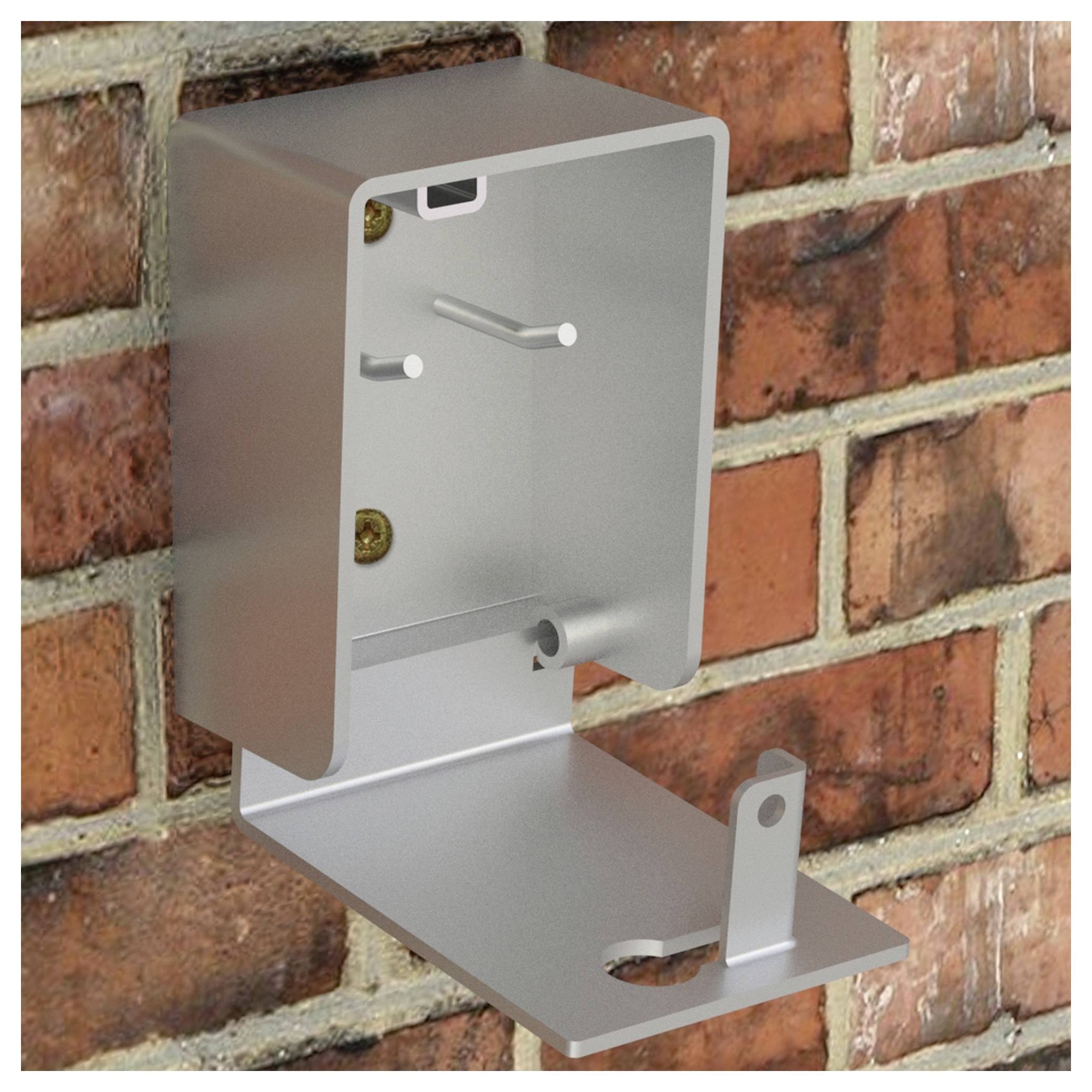 A metal enclosure mounted on a brick wall, designed for housing electronic or mechanical components, with an open front and bottom support.