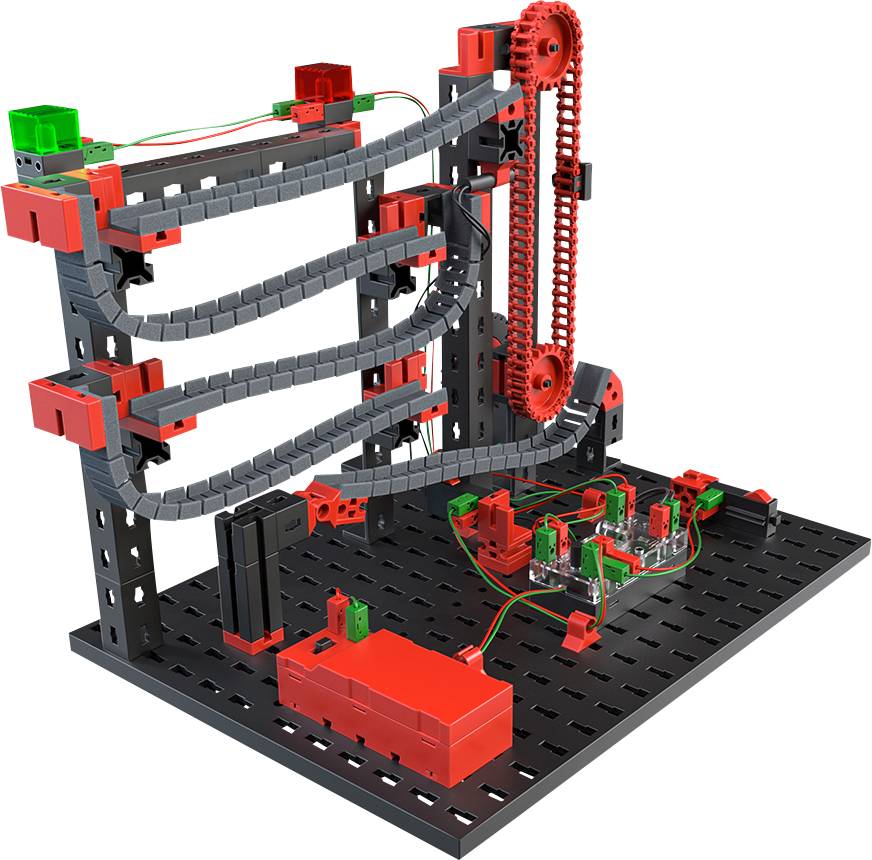 A marble run construction kit with red and grey components on a black base. Electronic components connect the parts.
