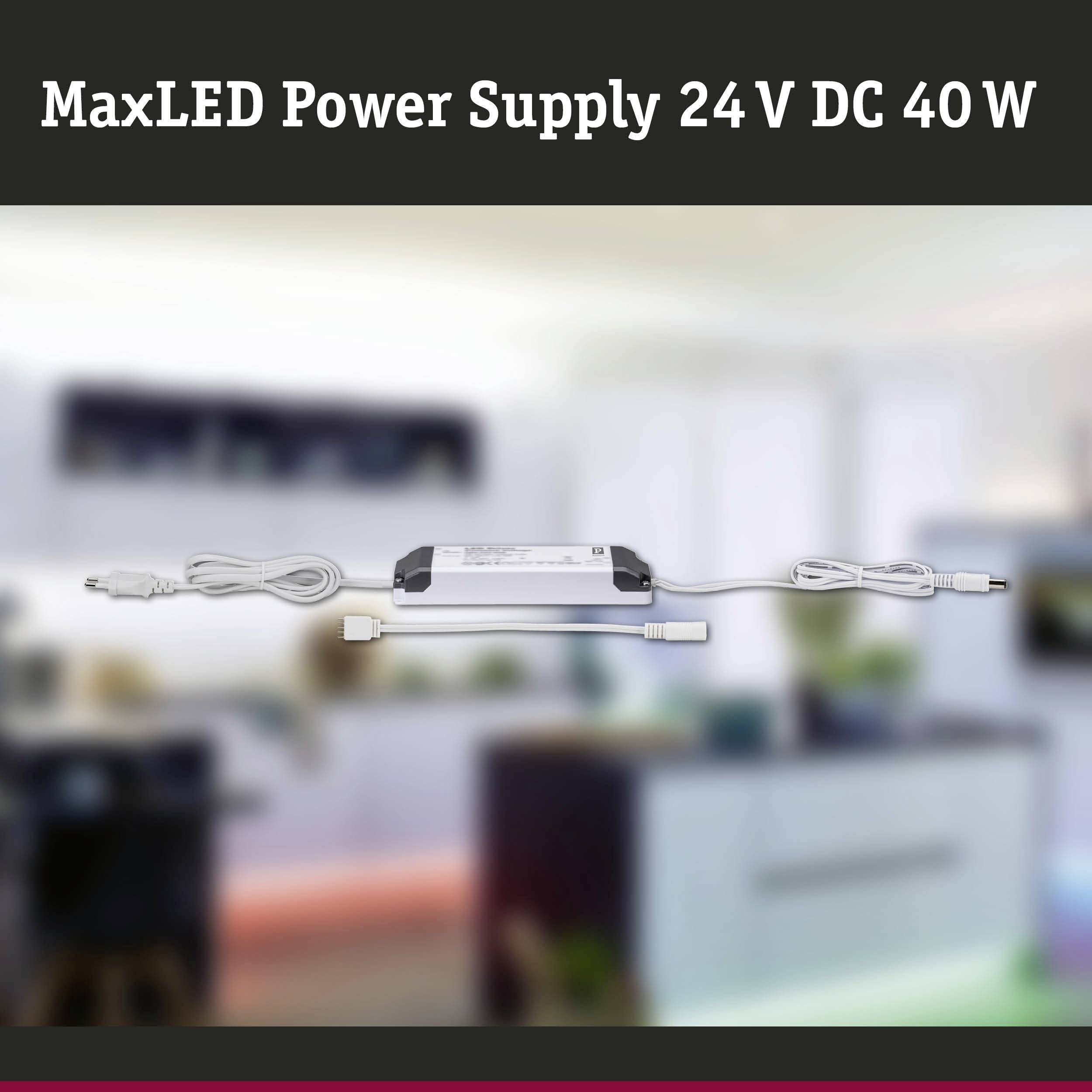 MaxLED Power Supply 24 V DC 40 W with Cable and Plug, blurred background with interior decor.