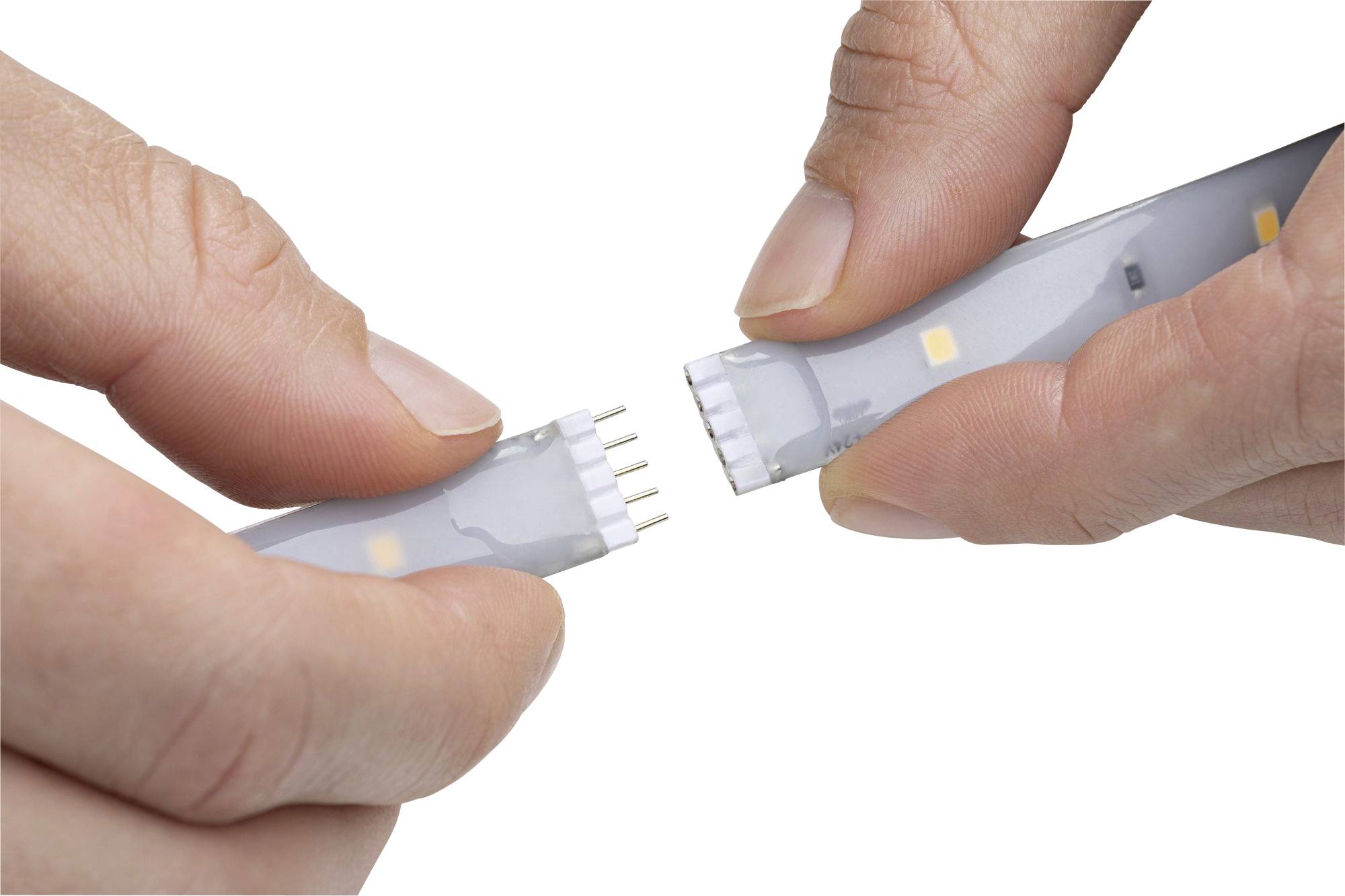 Two hands are connecting two sections of an LED strip by bringing the plug contacts together.