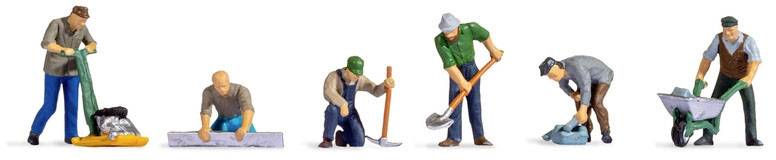 Six miniature figures simulate construction workers: a roller, a foundation slab, a spade, a shovel, a road compactor, a wheelbarrow.