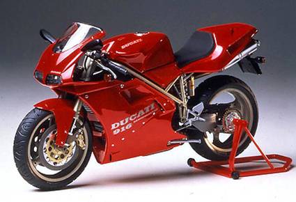 A red motorbike on a stand, captured from an angled side view. Caption reading 