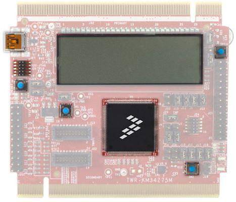 Red printed circuit board with a large chip in the centre, display screen at the top, and smaller components at the corners and sides.