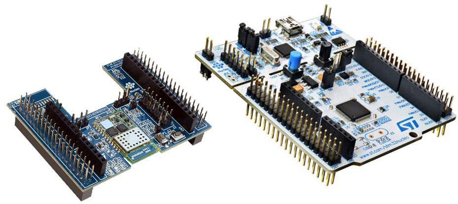Two development boards with blue printed circuit boards are shown, with a smaller one on the left featuring sensors, and a larger one on the right with multiple connectors.