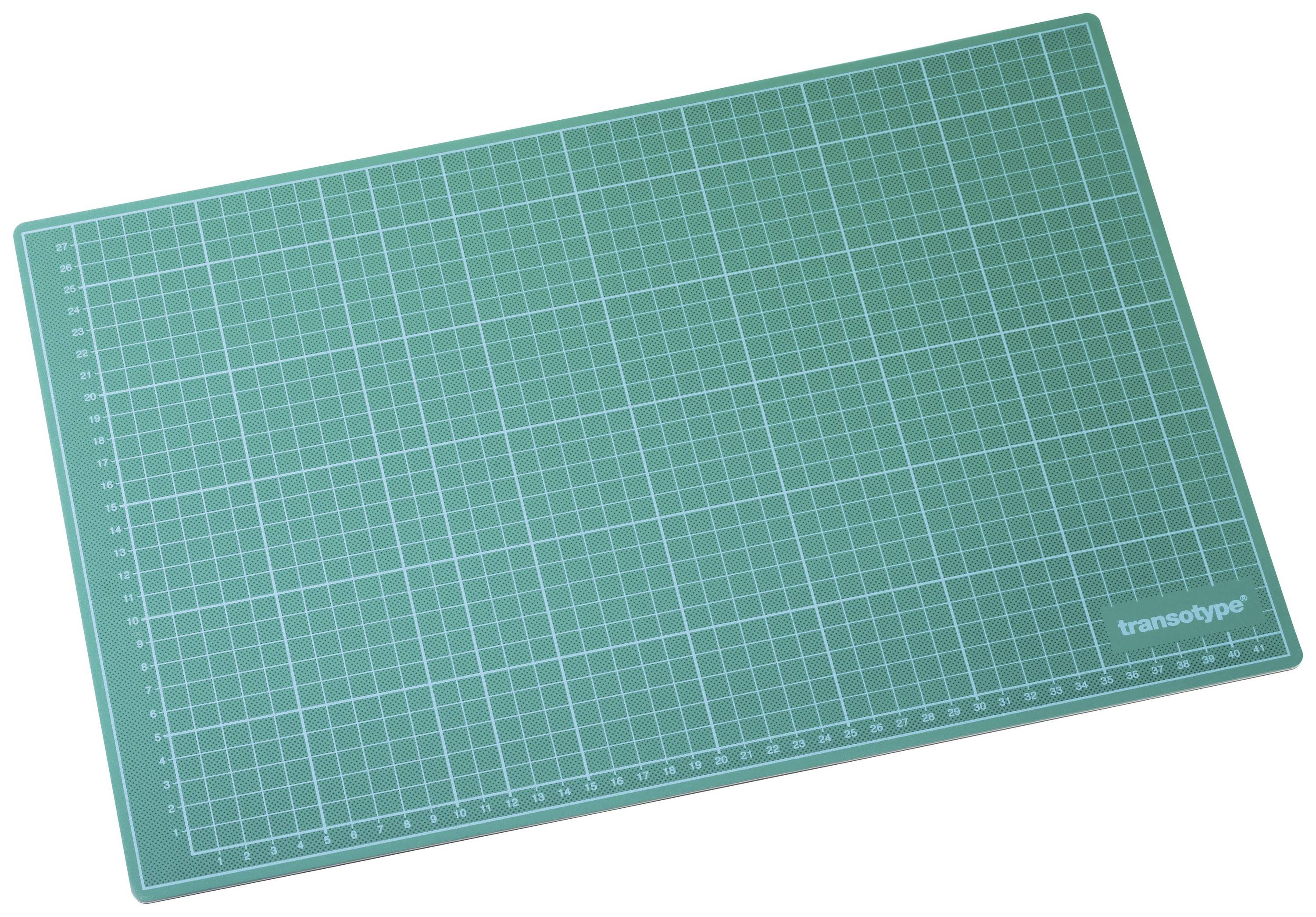 Green cutting mat with white grid lines and a centimetre scale along the edge, used for precise cutting and crafting.