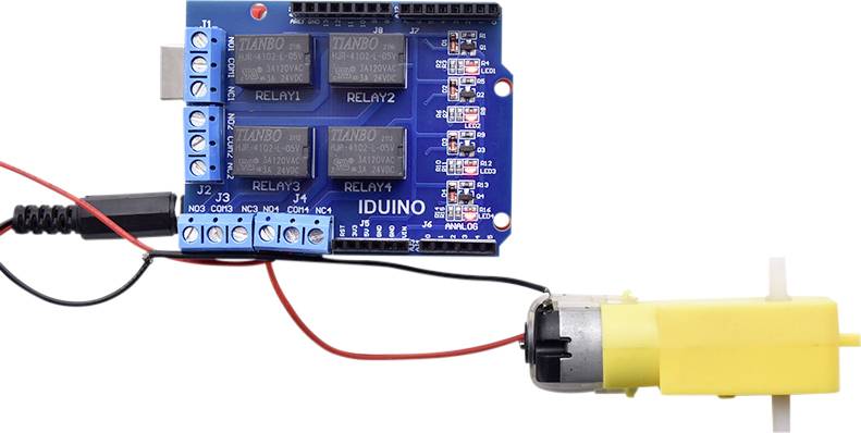 Electronic circuit with blue circuit board and yellow motor, connected by red and black cables. Markings: RELAY1 to RELAY4.