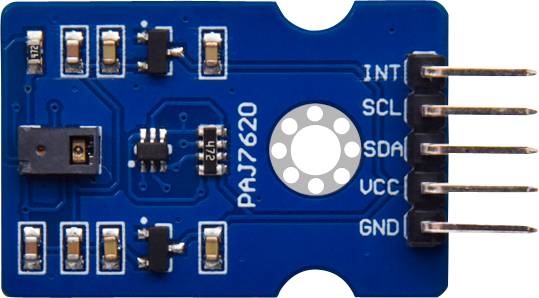 Sensor circuit board with the inscription 'PAJ7620', showing several electronic components and connections (INT, SCL, SDA, VCC, GND) on a blue PCB.
