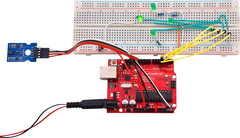 Red control circuit board connected with breadboard, green LEDs and sensor. Electronic circuit project demonstrates control.