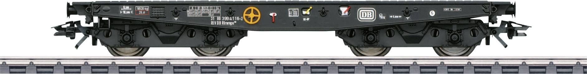 A flat goods wagon on a railway track, with no cargo. The wagon displays various technical markings and symbols.