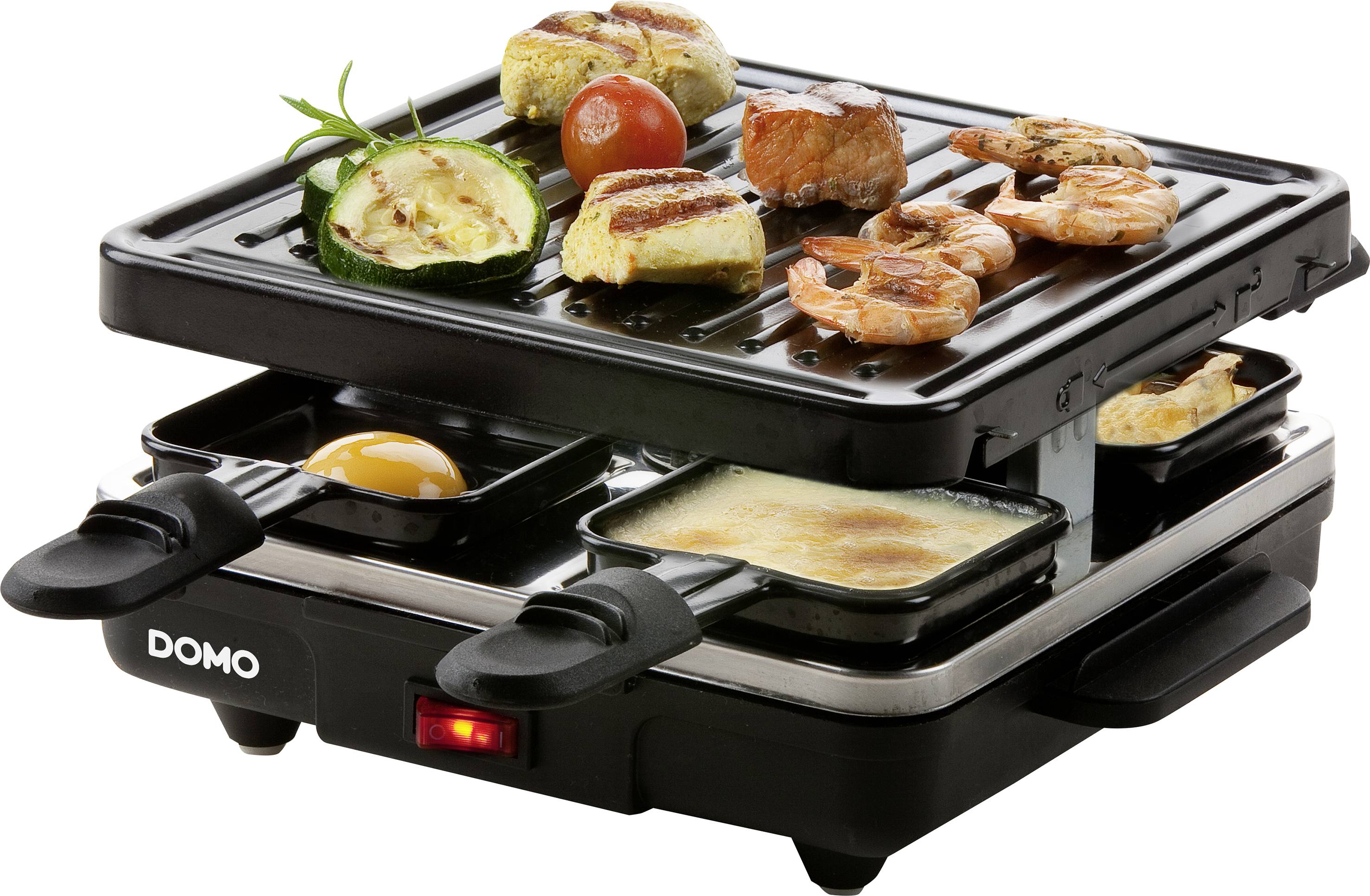 A tabletop grill with grill plates and small pans. Various foods are being grilled simultaneously: vegetables, meat and prawns.