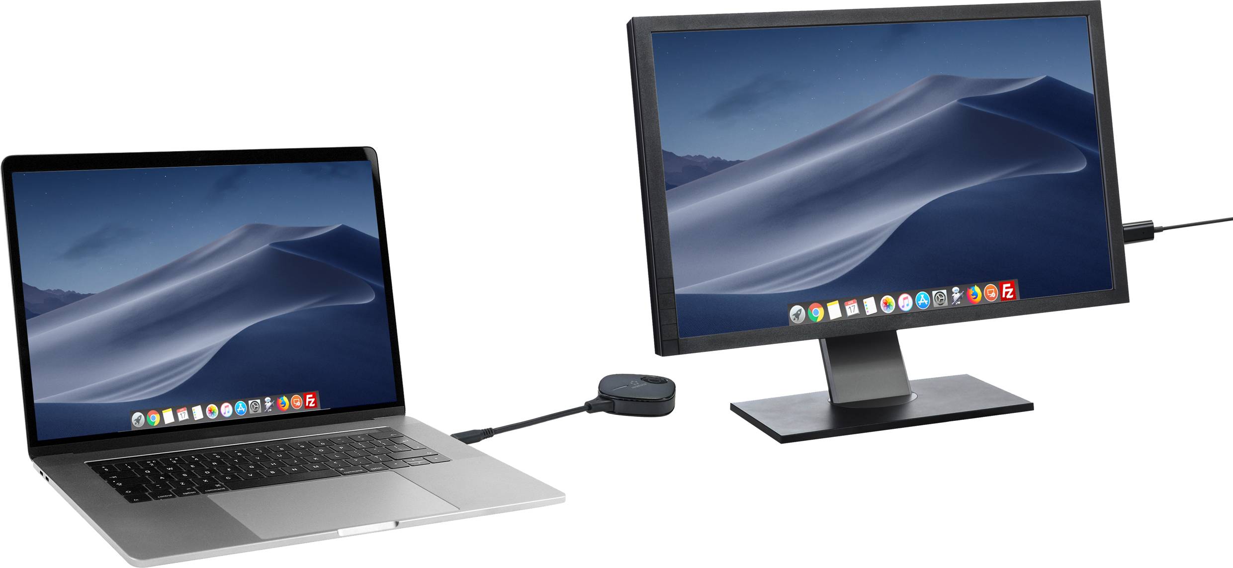 A laptop is connected to an external monitor via a cable and an adapter. Both screens are displaying the same sand dunes background image.