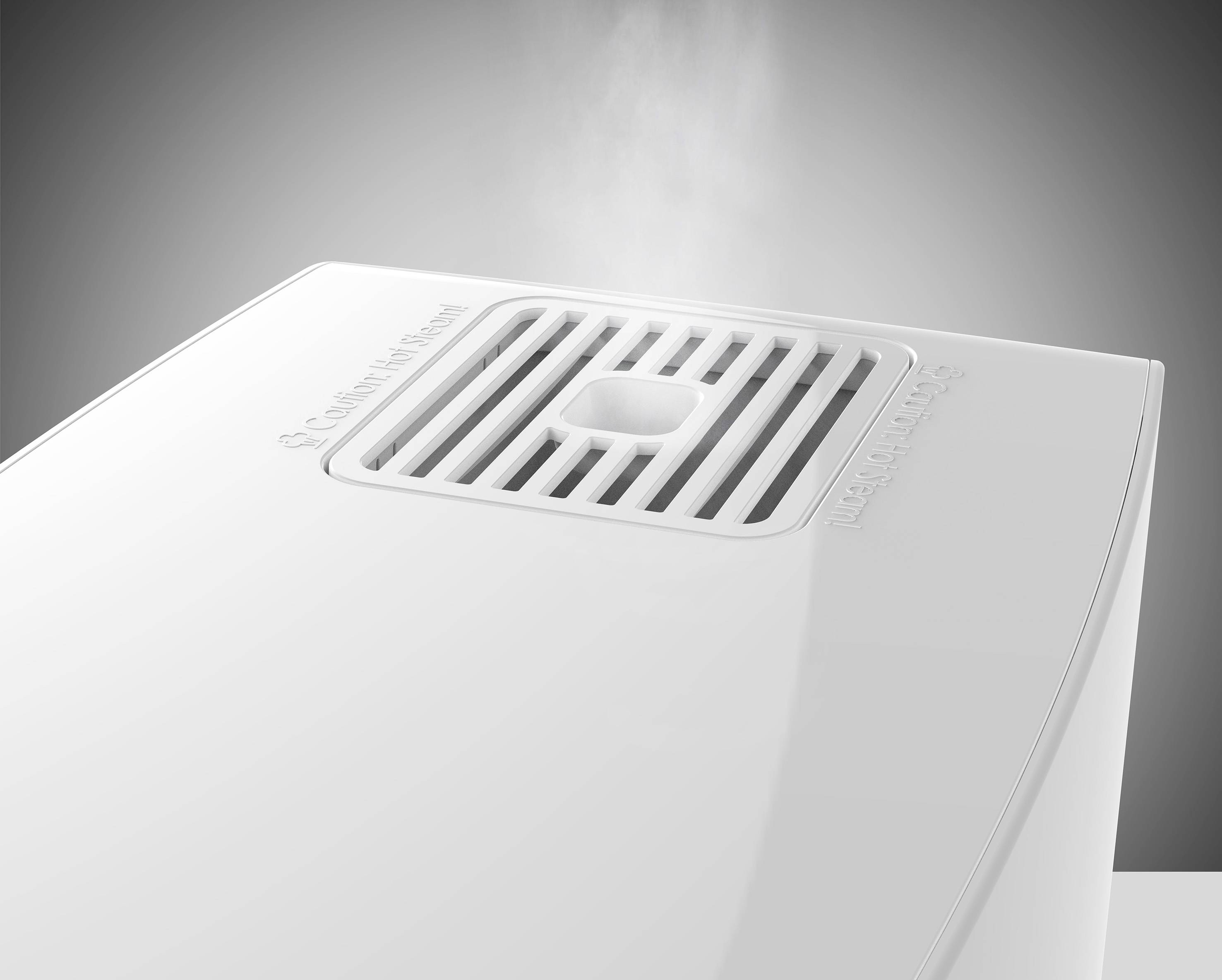 Humidifier on a table, steam rising; brand logo visible on top of the device, indicating active operation.